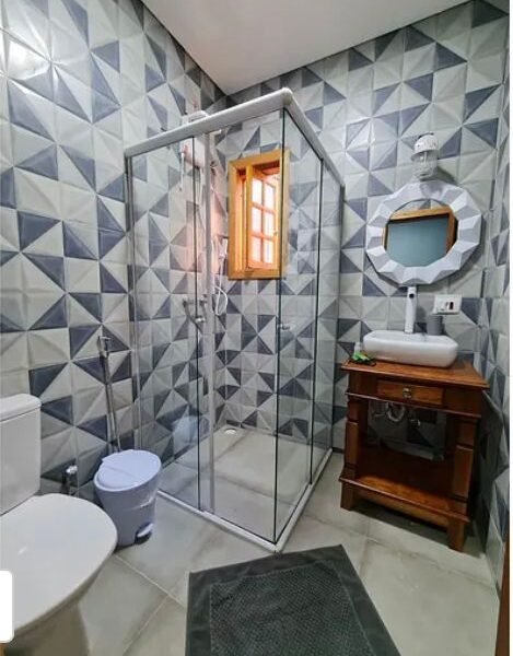 Suíte Grega, com banheira de hidromassagem, lareira elétrica e deck com vista para mata