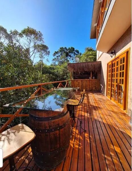 Suíte Grega, com banheira de hidromassagem, lareira elétrica e deck com vista para mata